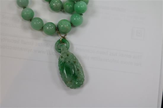 A double strand graduated jadeite bead necklace with carved jadeite pendant, pendant 29mm.